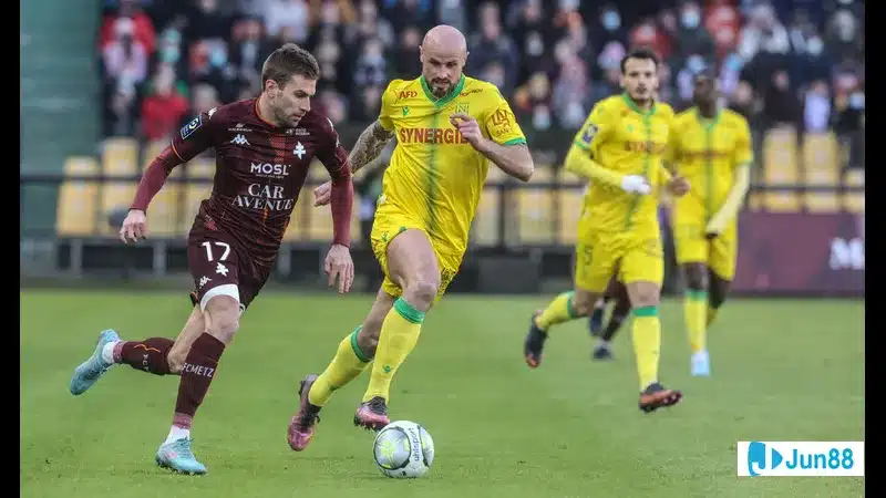 Cầu thủ của Nantes và Metz đua tốc độ để tranh bóng trước khán đài đầy khán giả Cầu thủ của Nantes và Metz đua tốc độ để tranh bóng trước khán đài đầy khán giả